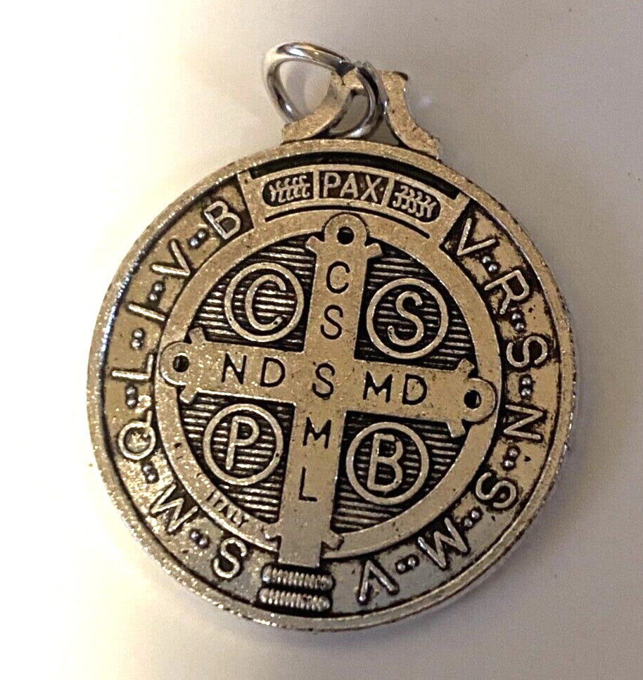 Large silver tone Saint Benedict medal, 1.25 inches in diameter, featuring religious imagery, designed for spirituality and devotion.