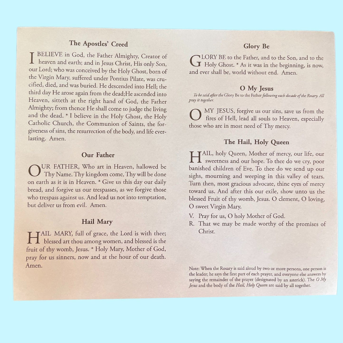 Close-up of Bob and Penny Lord's rosary prayer card featuring Christian holy card design with prayer instructions and religious symbols.