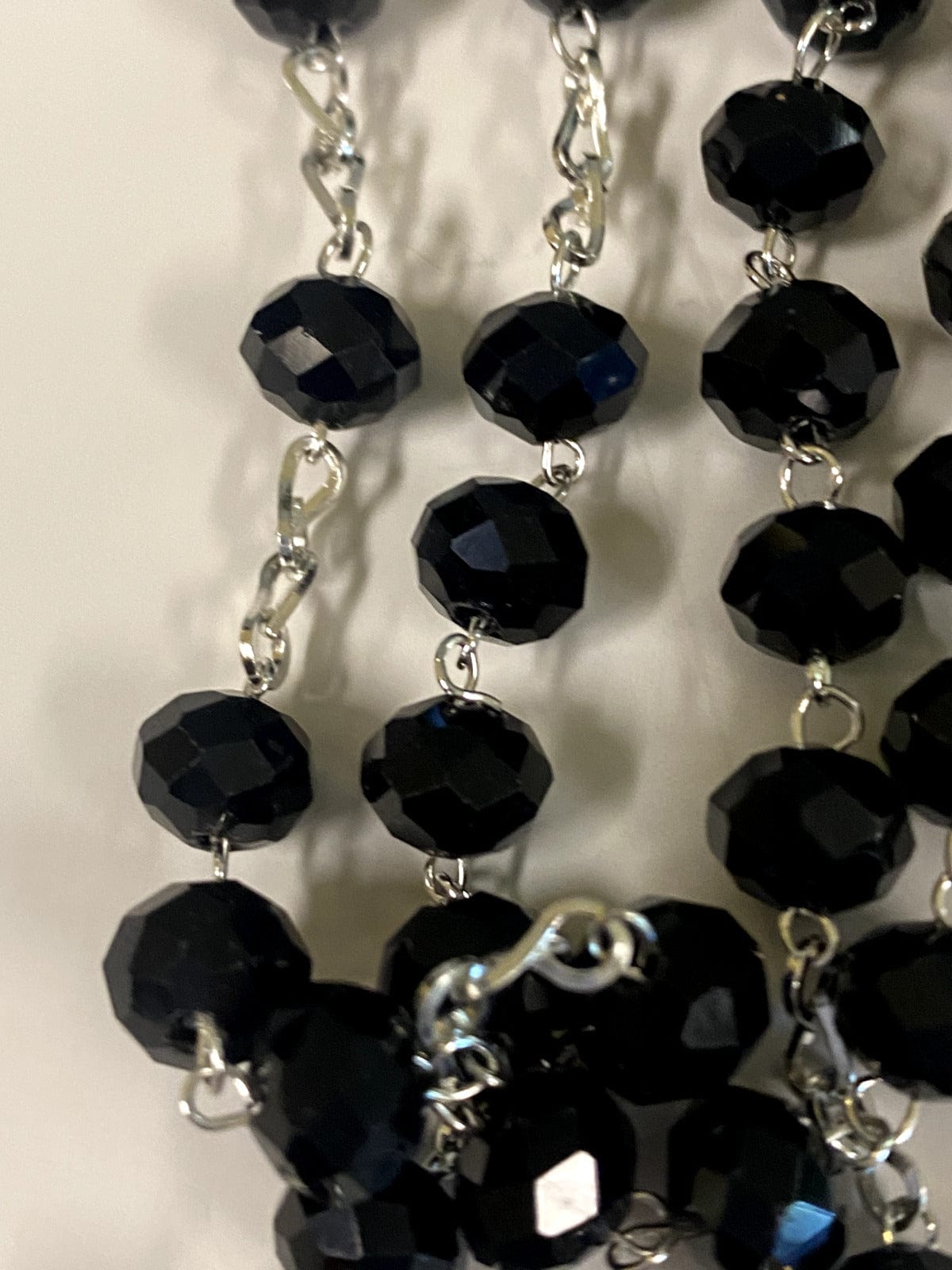 Black handmade Blessed Mother rosary from Colombia with beads and crucifix, crafted by Bob and Penny Lord for Christian spirituality.