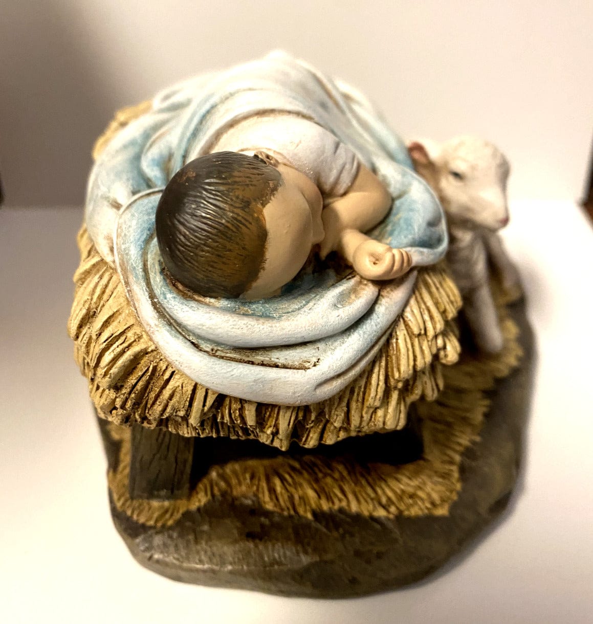 Sleeping Baby Jesus statue with lamb, part of Bob and Penny Lord's religious collectibles, depicting a peaceful nativity scene.