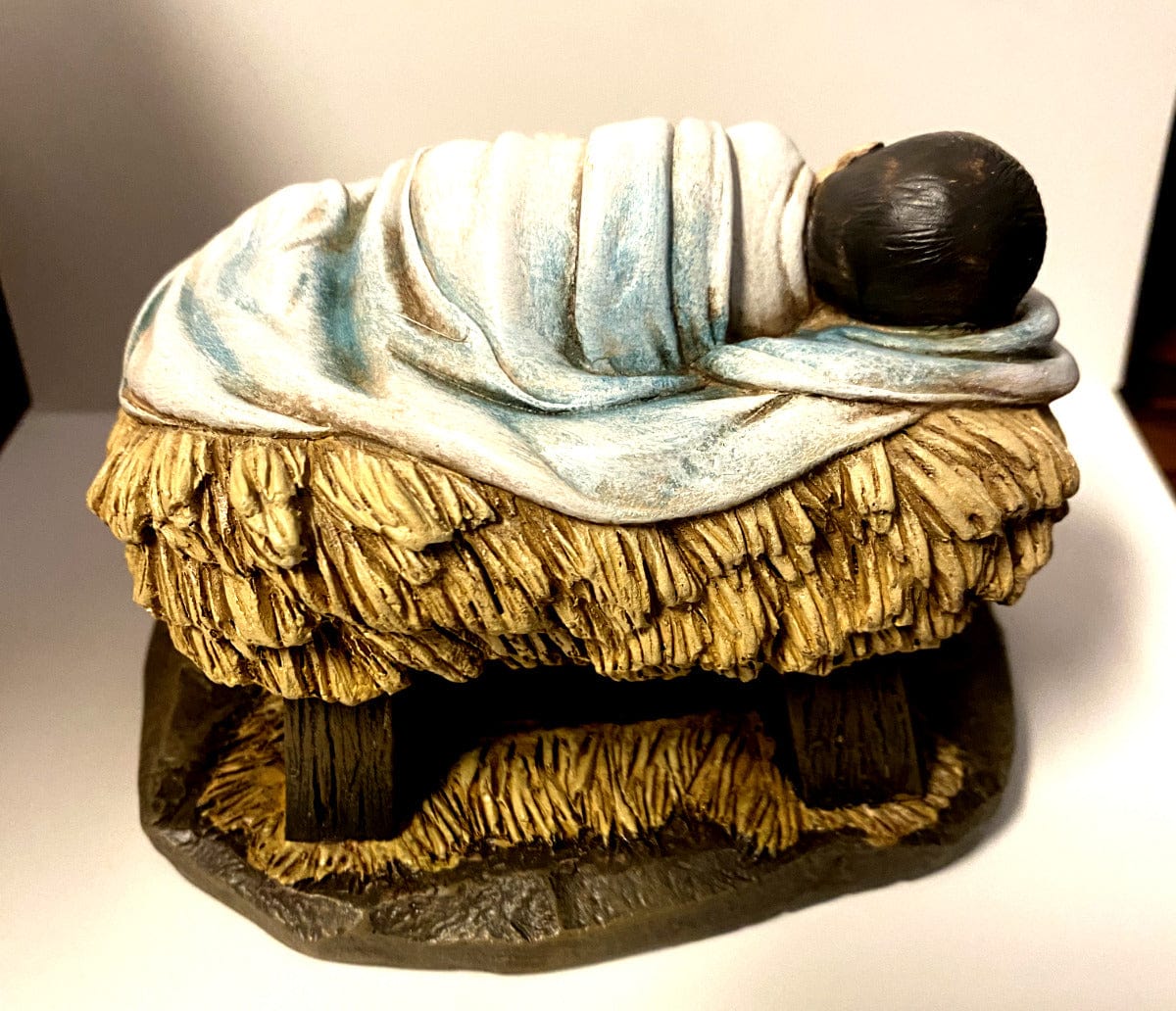 Sleeping Baby Jesus statue with lamb, part of Christian religious collectibles by Bob and Penny Lord, symbolizing God's gift of love.
