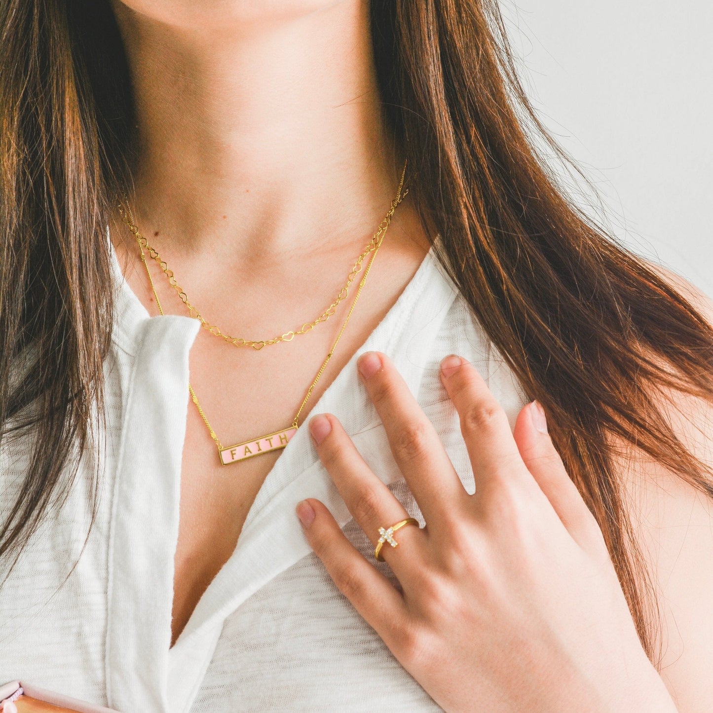 Gold and silver Joyful Hearts layering necklace by AMADI Jewelry, featuring multiple heart-shaped charms on a delicate chain.