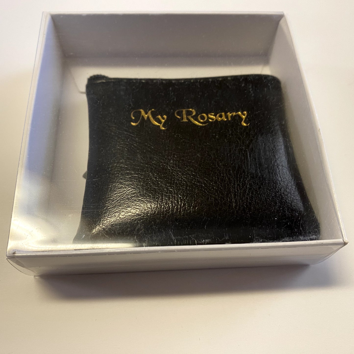 Black leather rosary pouch with embossed Christian cross, designed by Bob and Penny Lord Journeys of Faith for religious collectibles.