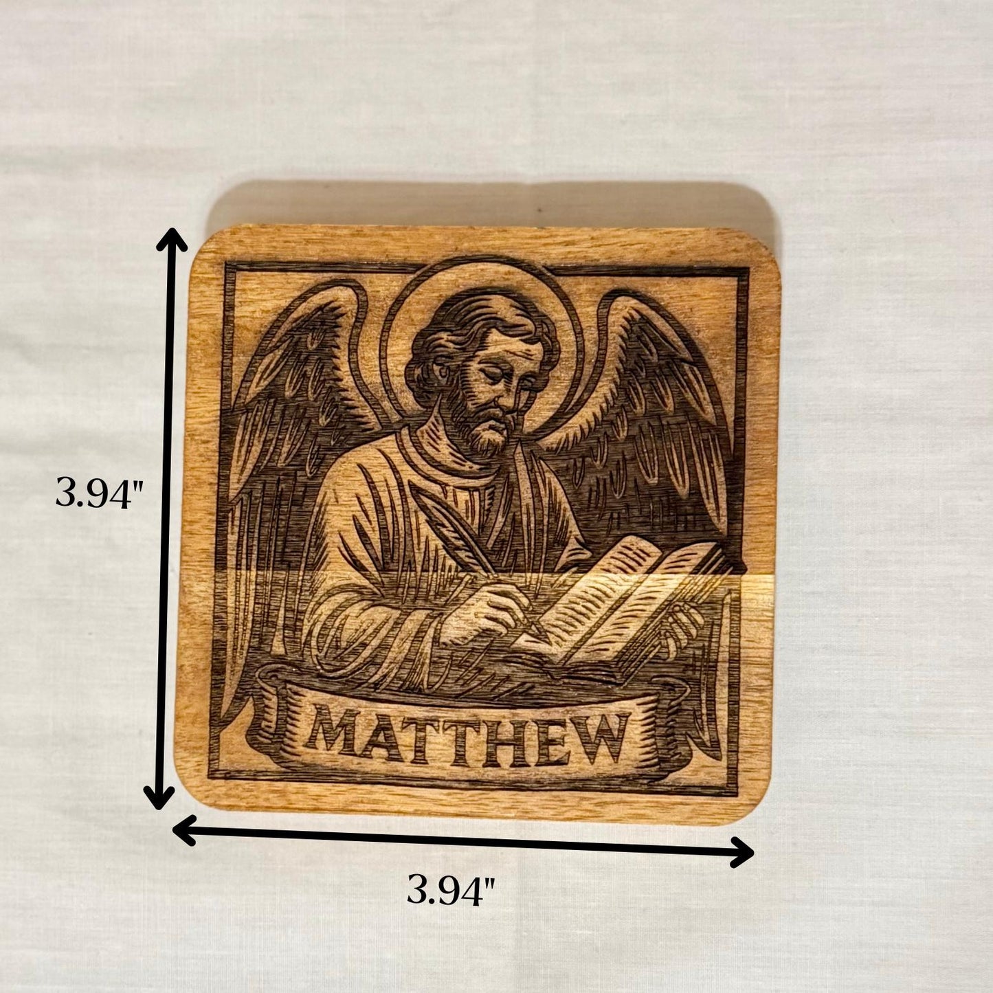 Set of wooden evangelist coasters with religious Christian artwork from St. Augustine Prints, featuring intricate engraved designs.