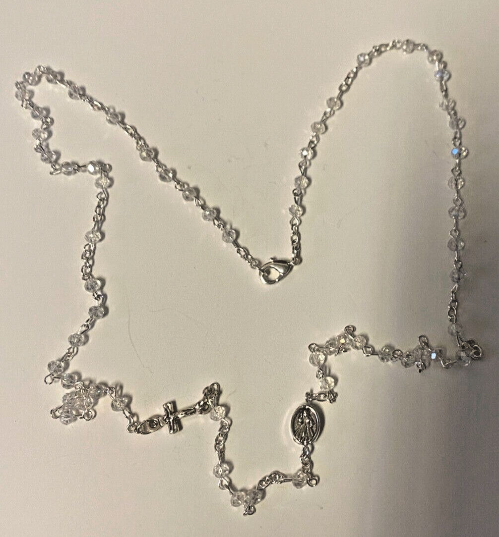 Divine Mercy clear glass beads rosary necklace with medal, Christian religious jewelry by Bob and Penny Lord, close-up view.
