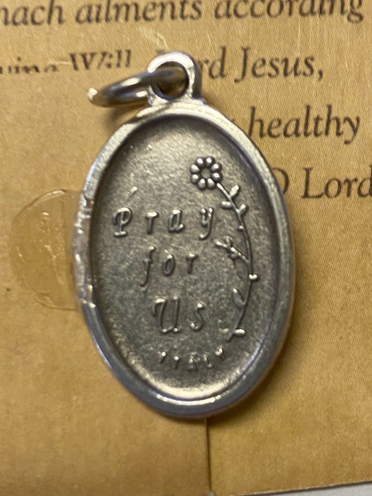 Saint Charles Borromeo prayer card and medal from Bob and Penny Lord, featuring religious imagery and detailed design.
