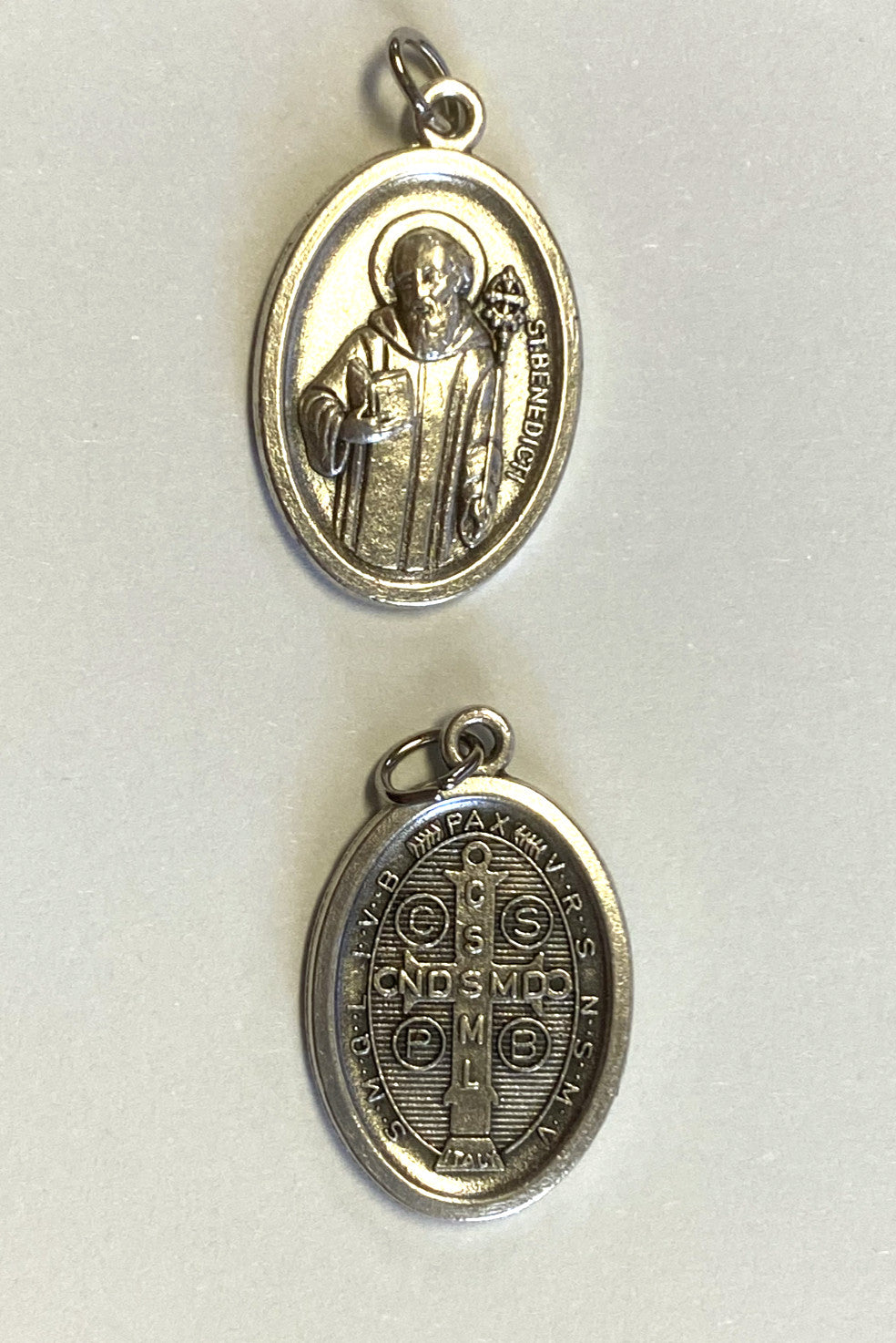 Silver tone Saint Benedict medal by Bob and Penny Lord, religious collectible featuring detailed Christian design.