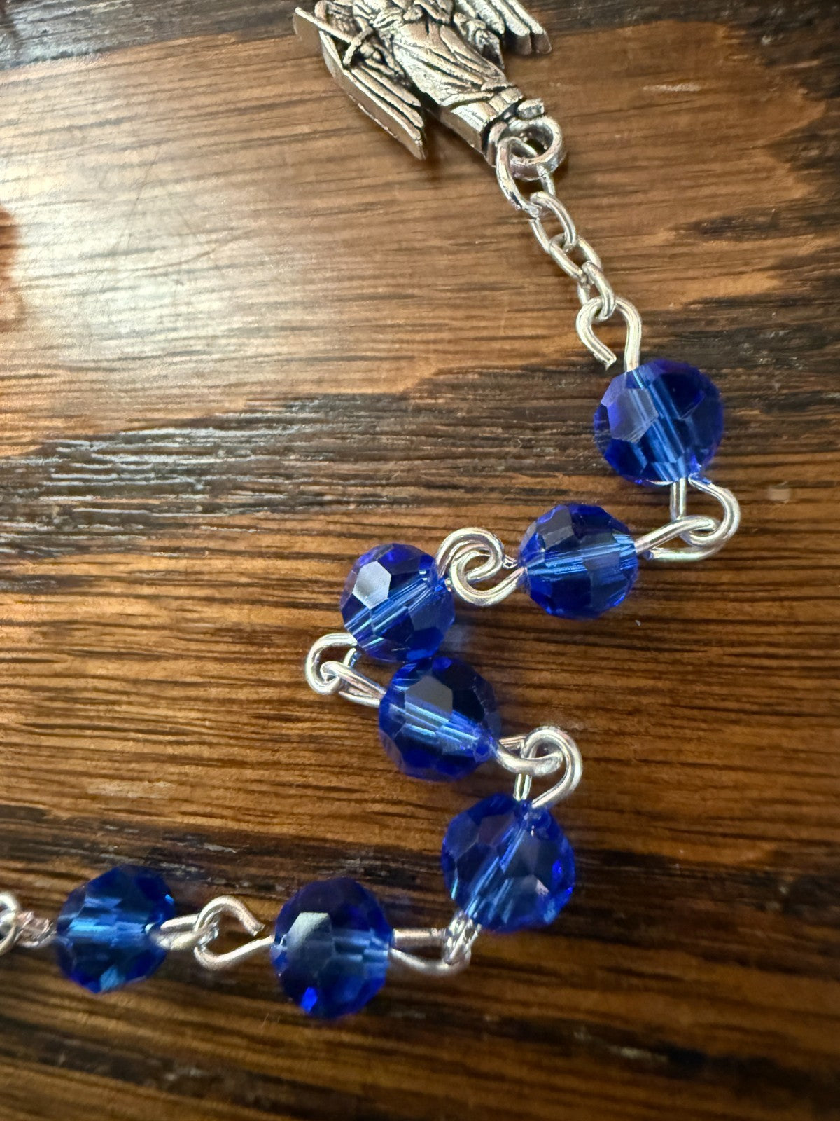 Blue glass beads rosary featuring Saint Michael and archangels, crafted by Bob and Penny Lord, with detailed medals and religious symbols.