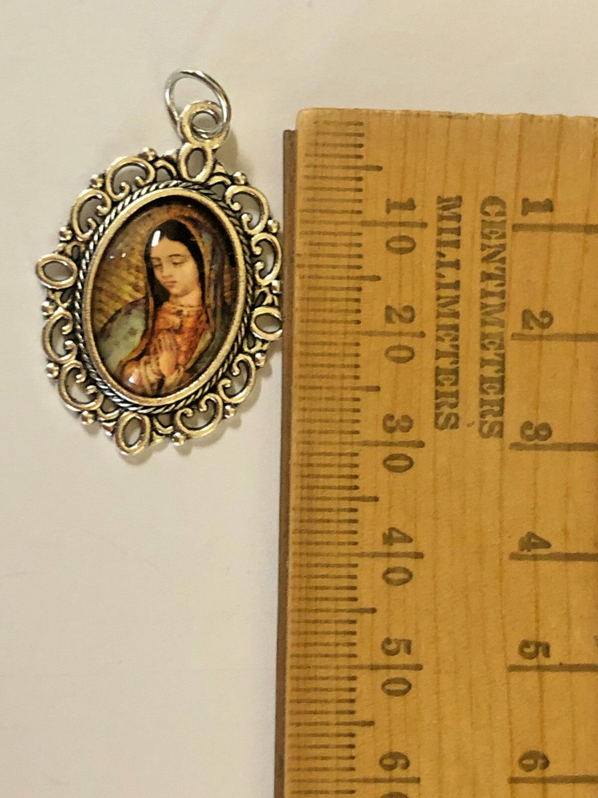 Color image of Our Lady of Guadalupe medal with detailed religious design, crafted by Bob and Penny Lord, for spiritual collection.