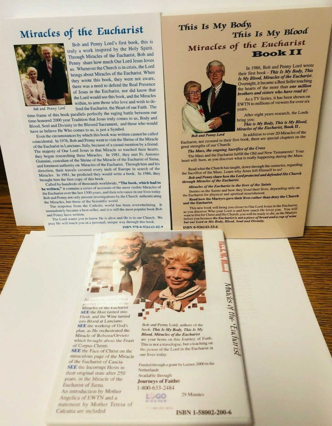 Books titled "This is My Body, This is My Blood" by Bob and Penny Lord, featuring religious content on Eucharist, with a DVD.