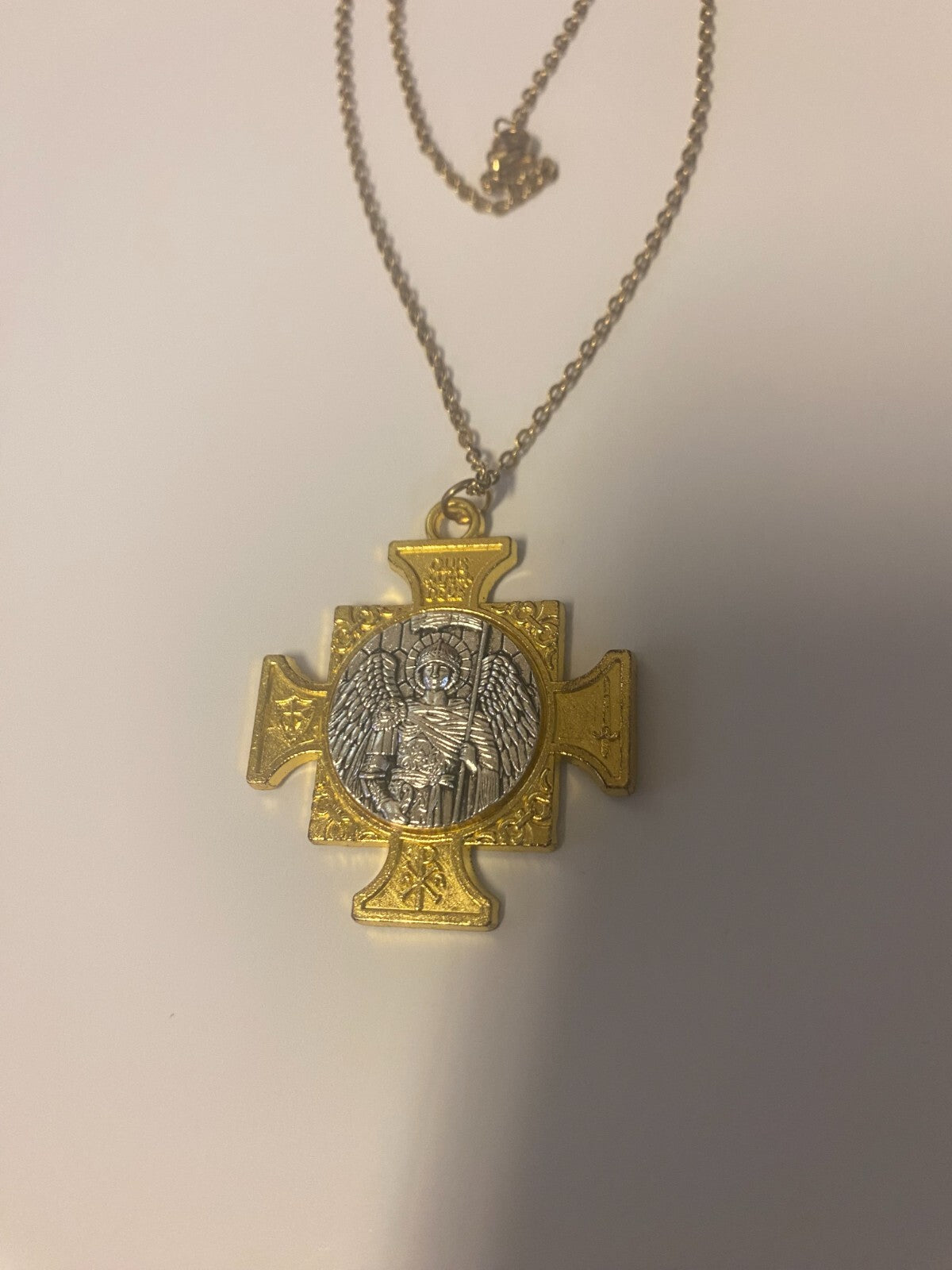 Saint Michael the Archangel iron cross pendant with gold and silver tones, featuring detailed religious art by Bob and Penny Lord.