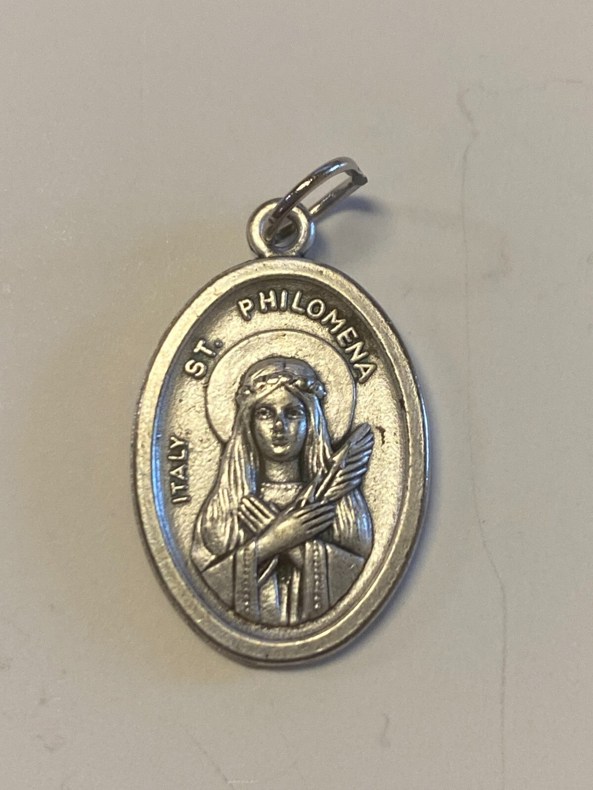 Silver Saint Philomena medal from Bob and Penny Lord, featuring religious imagery, designed for Christian collectibles and spirituality.