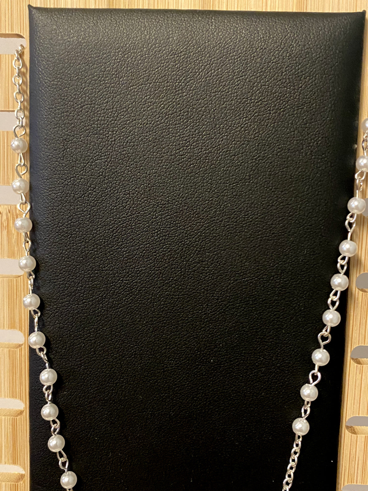 White faux pearl rosary necklace, 18 inches long, with metal beads and crucifix, designed by Bob and Penny Lord.