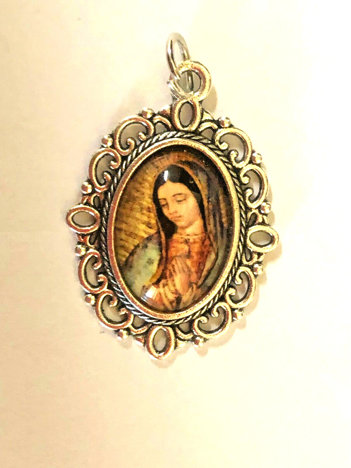 Color image of Our Lady of Guadalupe medal by Bob and Penny Lord, featuring detailed religious Christian iconography.
