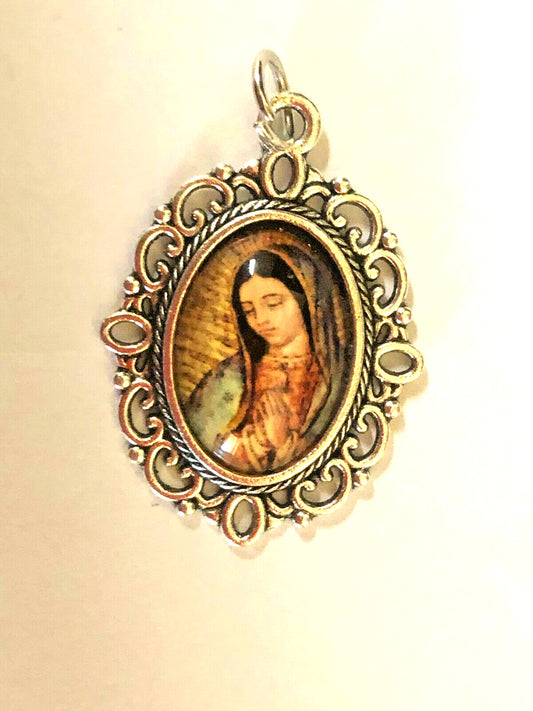 Color image of Our Lady of Guadalupe medal by Bob and Penny Lord, featuring detailed religious Christian iconography.
