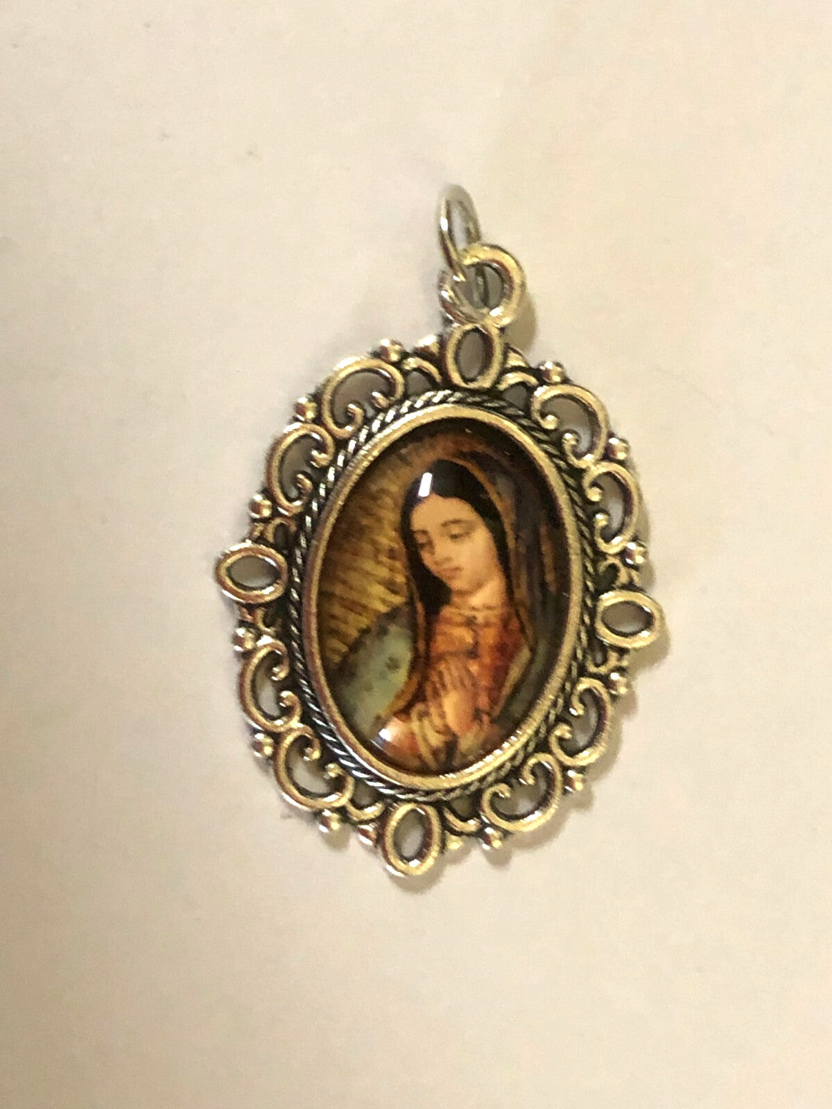 Color image of Our Lady of Guadalupe medal by Bob and Penny Lord, featuring religious Christian medal with detailed depiction of Virgin Mary.