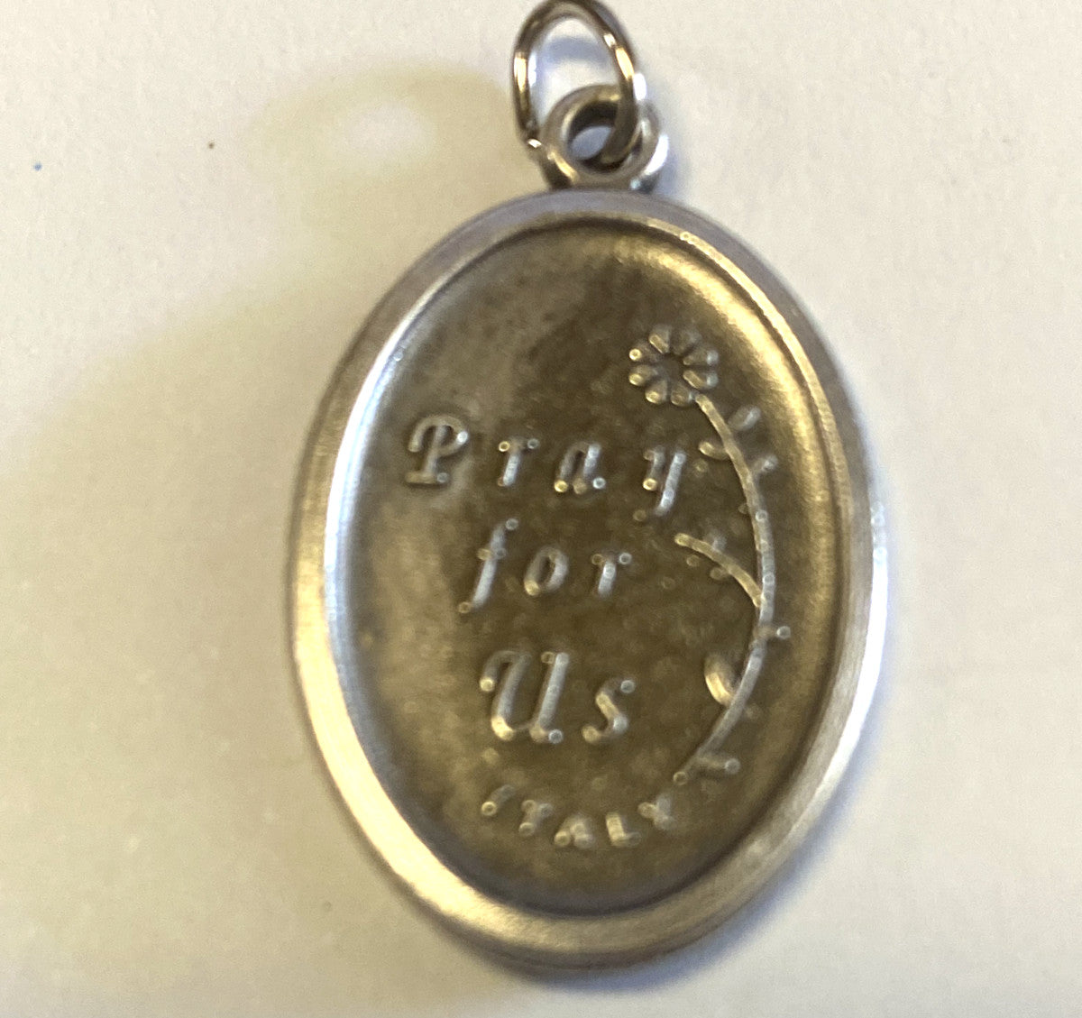 Silver tone Saint Francis of Assisi medal from Italy, religious Christian collectible by Bob and Penny Lord, detailed religious iconography.