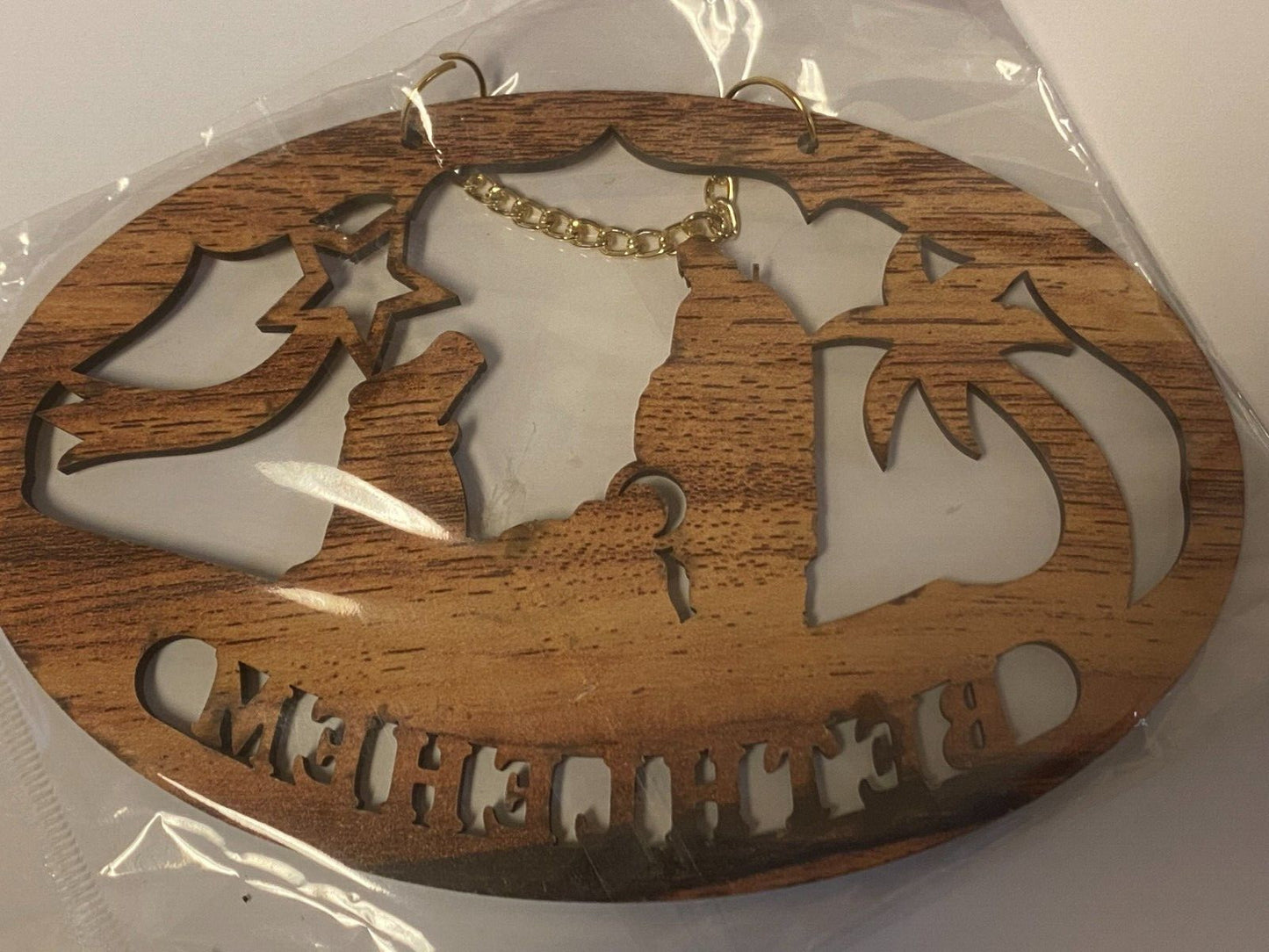 Carved olive wood Nativity Scene wall sign by Bob and Penny Lord, depicting the Holy Family and angels in detailed relief.