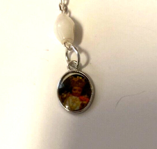 Infant of Prague charm on a decade rosary bracelet featuring Catholic religious jewelry, with beads and metal charm.