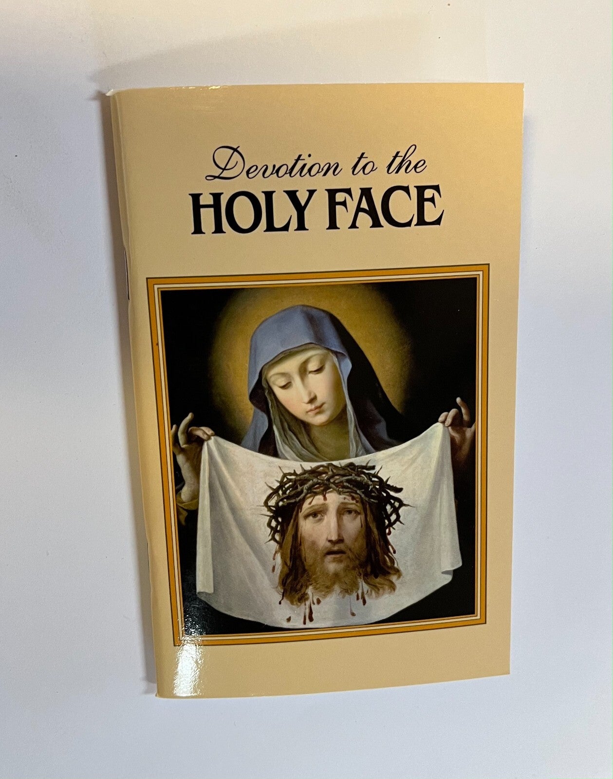 Book titled "Devotion to the Holy Face of Jesus" by Bob and Penny Lord, featuring religious imagery on the cover.