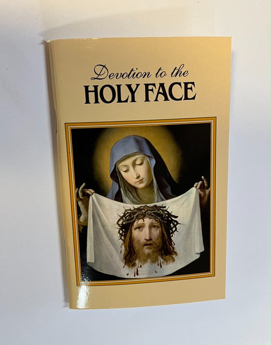 Book titled "Devotion to the Holy Face of Jesus" by Bob and Penny Lord, featuring religious imagery on the cover.