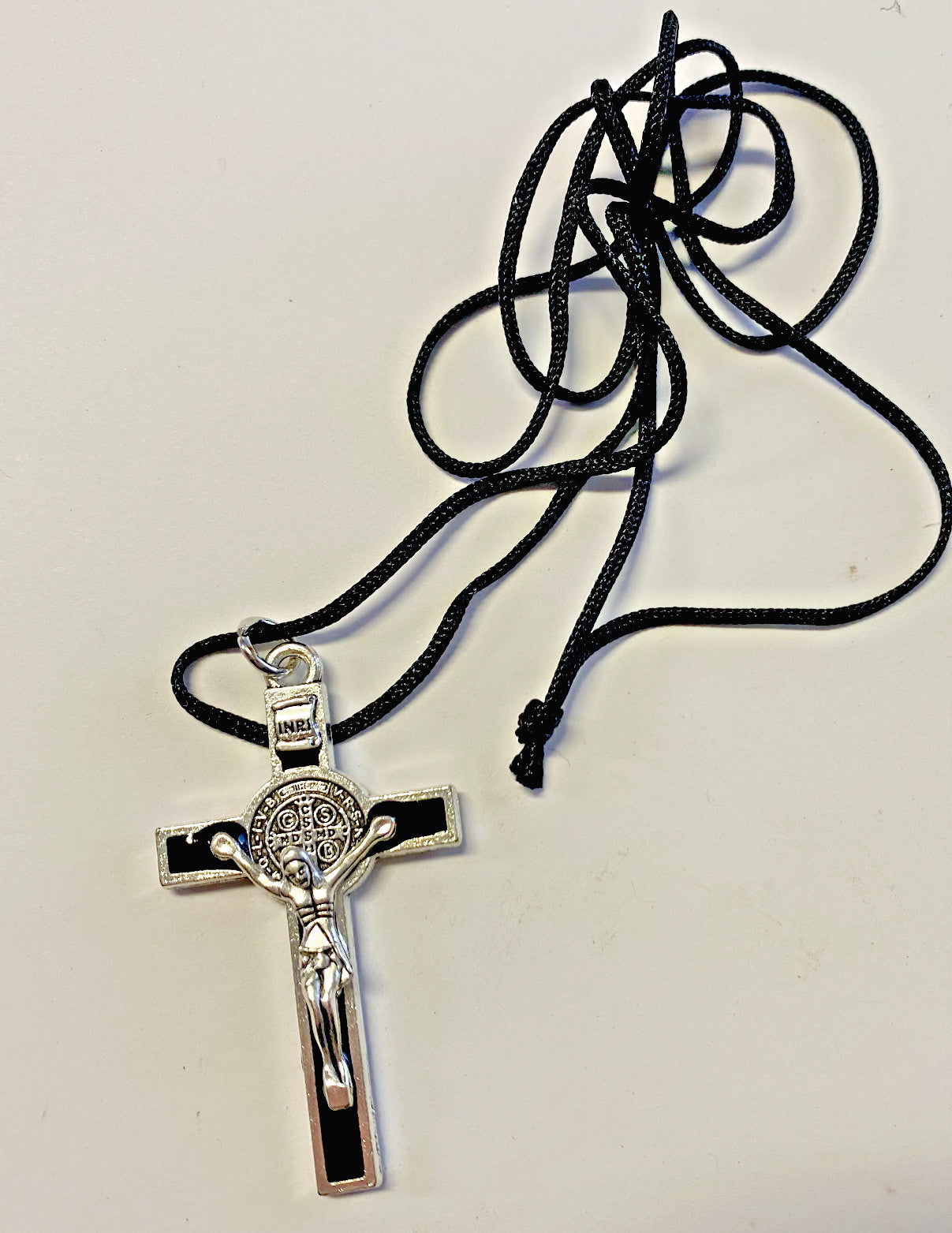 Black and silver Saint Benedict crucifix pendant on cord necklace, ethnic tribal jewelry, unbranded religious pendant display