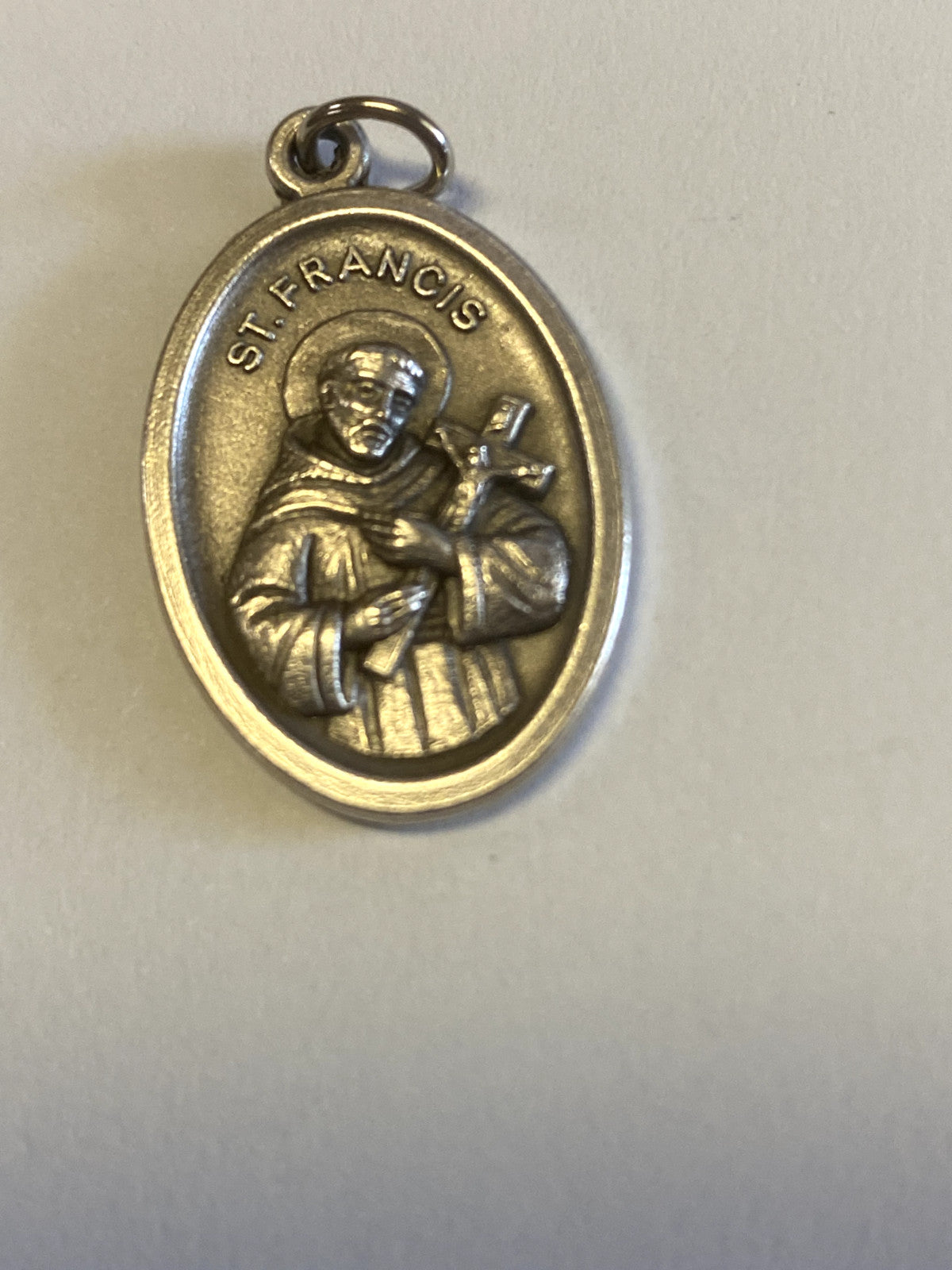 Silver tone Saint Francis of Assisi medal from Italy, Christian religious collectible with detailed religious imagery and craftsmanship.