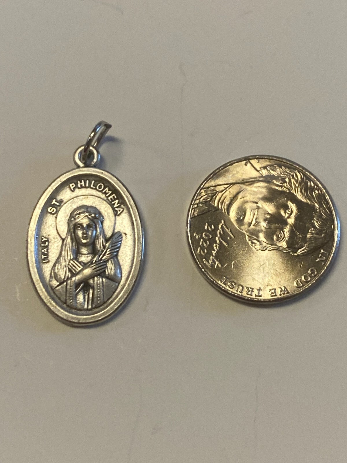 Silver Saint Philomena medal from Bob and Penny Lord, featuring religious Christian iconography, used as a spiritual collectible.
