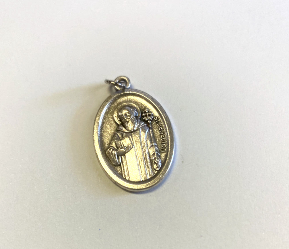 Silver tone Saint Benedict medal from Bob and Penny Lord, featuring religious symbols and detailed craftsmanship.