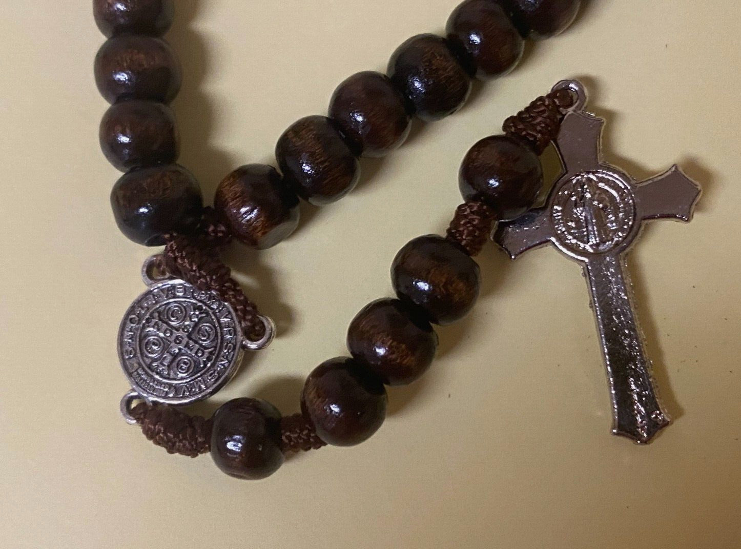 Wood Padre Pio rosary box with Christian rosary, handcrafted in Colombia, featuring detailed religious design and wooden construction.