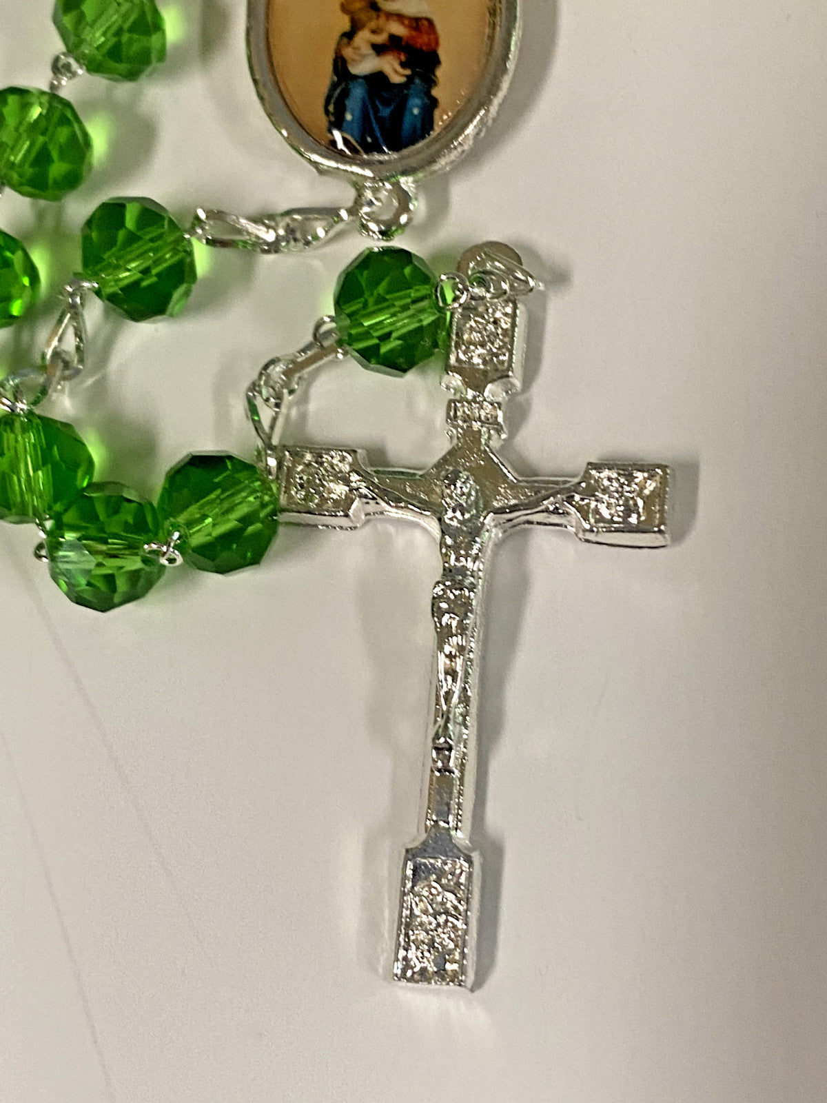 Handmade green Our Lady of Mount Carmel rosary from Colombia featuring beads and a crucifix, crafted by Bob and Penny Lord.
