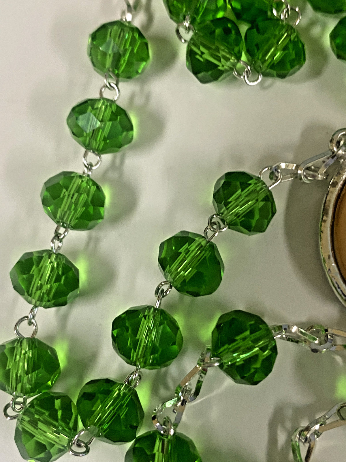 Handmade green Our Lady of Mount Carmel rosary by Bob and Penny Lord, featuring beads and religious medal, from Colombia.