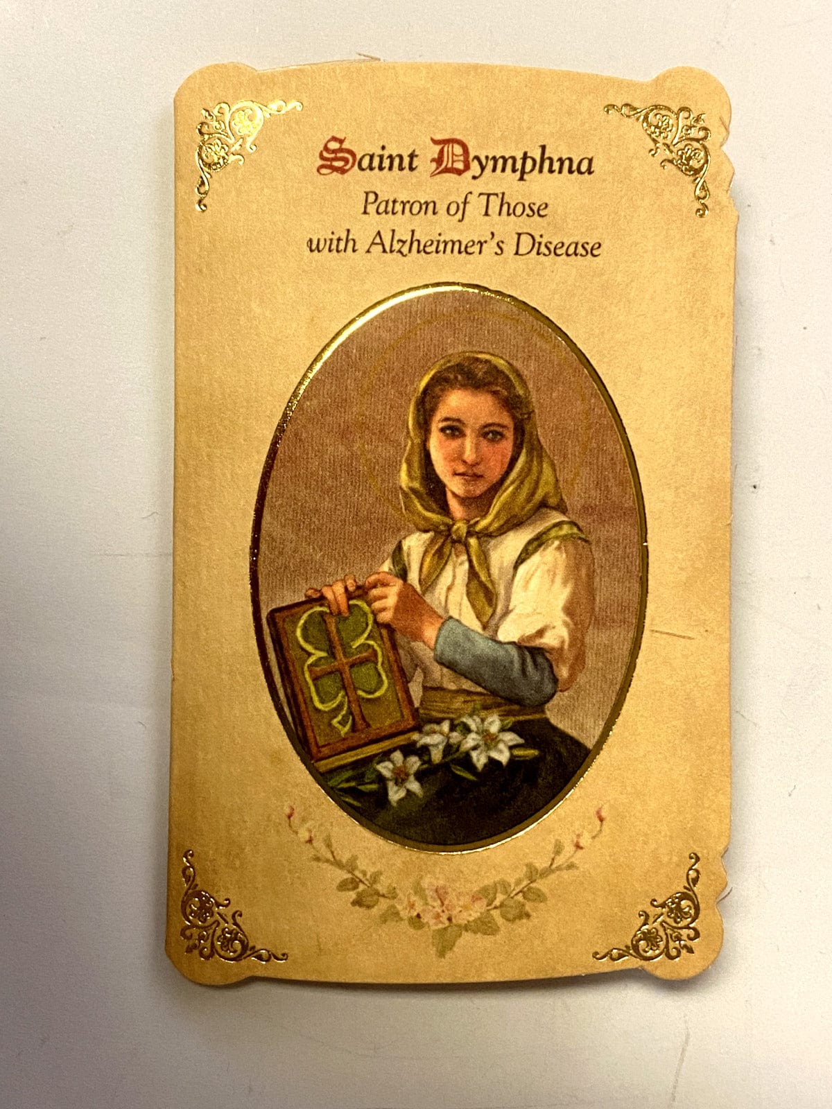 Saint Dymphna prayer card and medal from Bob and Penny Lord, featuring Christian religious imagery and spiritual symbolism.