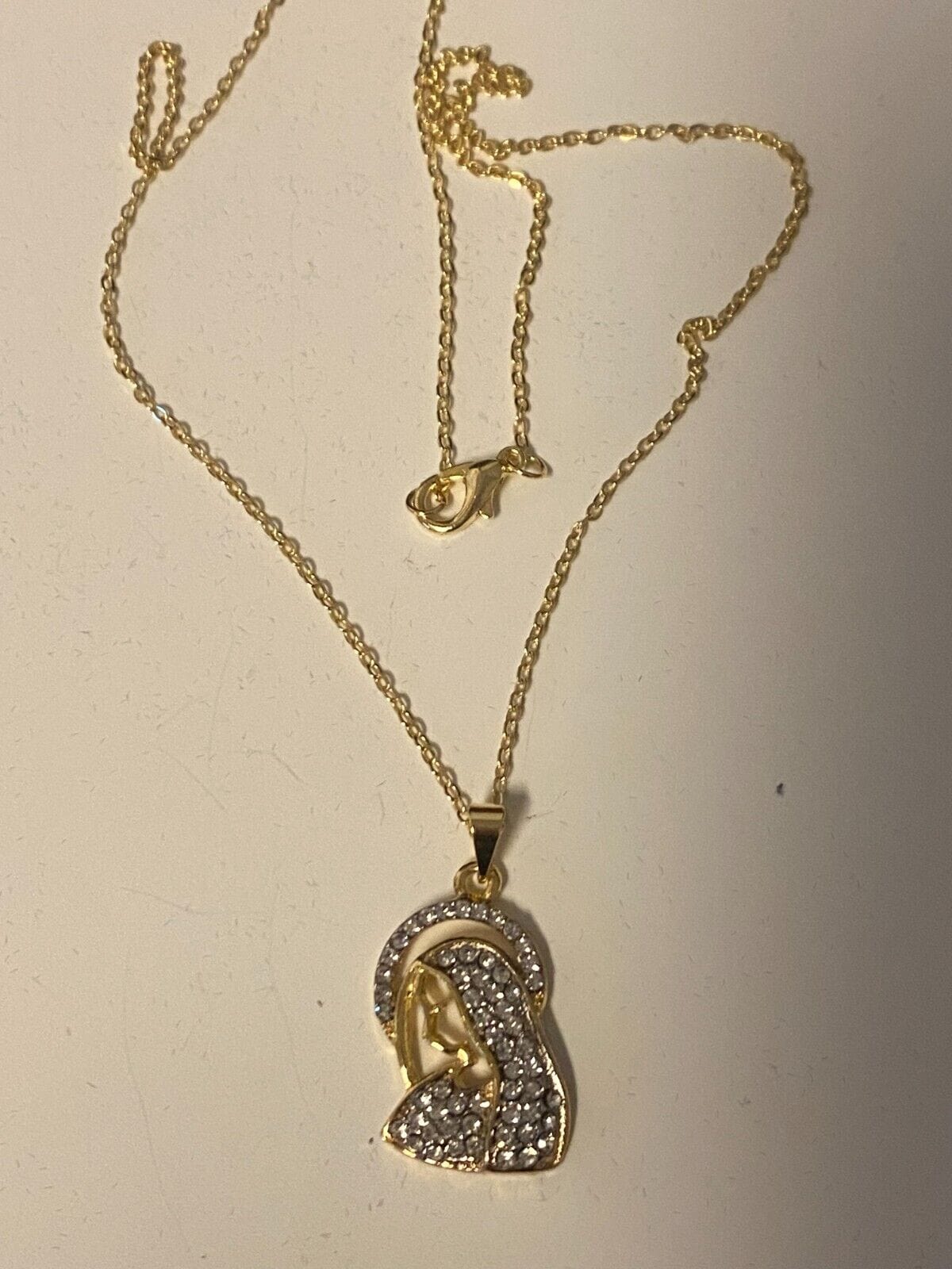 Brazilian gold-plated Blessed Mother necklace, 20-inch fashion jewelry pendant featuring religious imagery, on a chain.