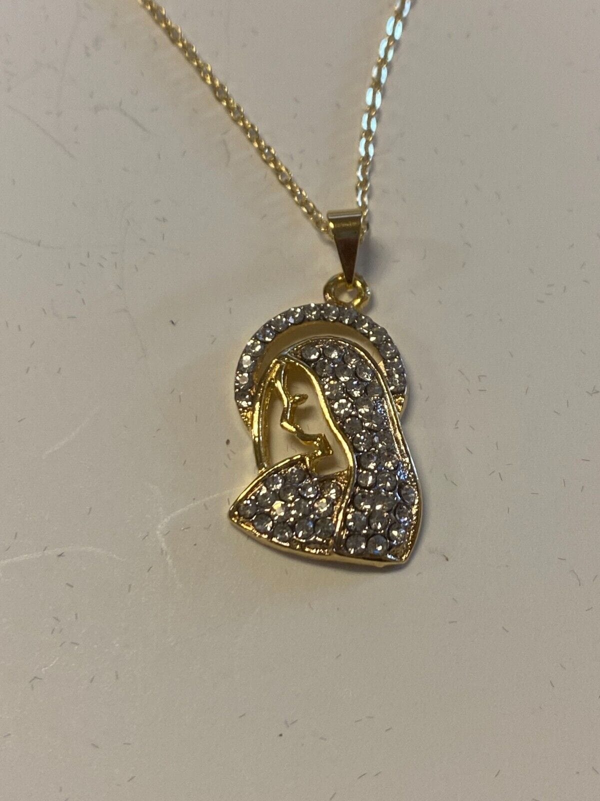 Brazilian gold-plated Blessed Mother necklace, 20-inch fashion jewelry with pendant, featuring intricate religious design and chain detail.