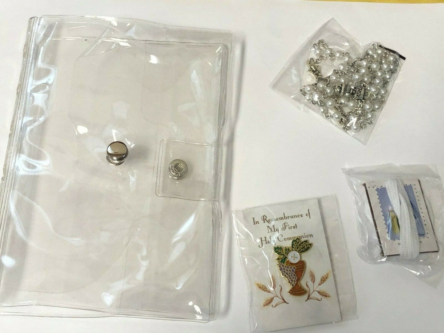 Girl's First Holy Communion wallet gift set, includes five Christian-themed collectibles, with religious symbols and decorative designs.