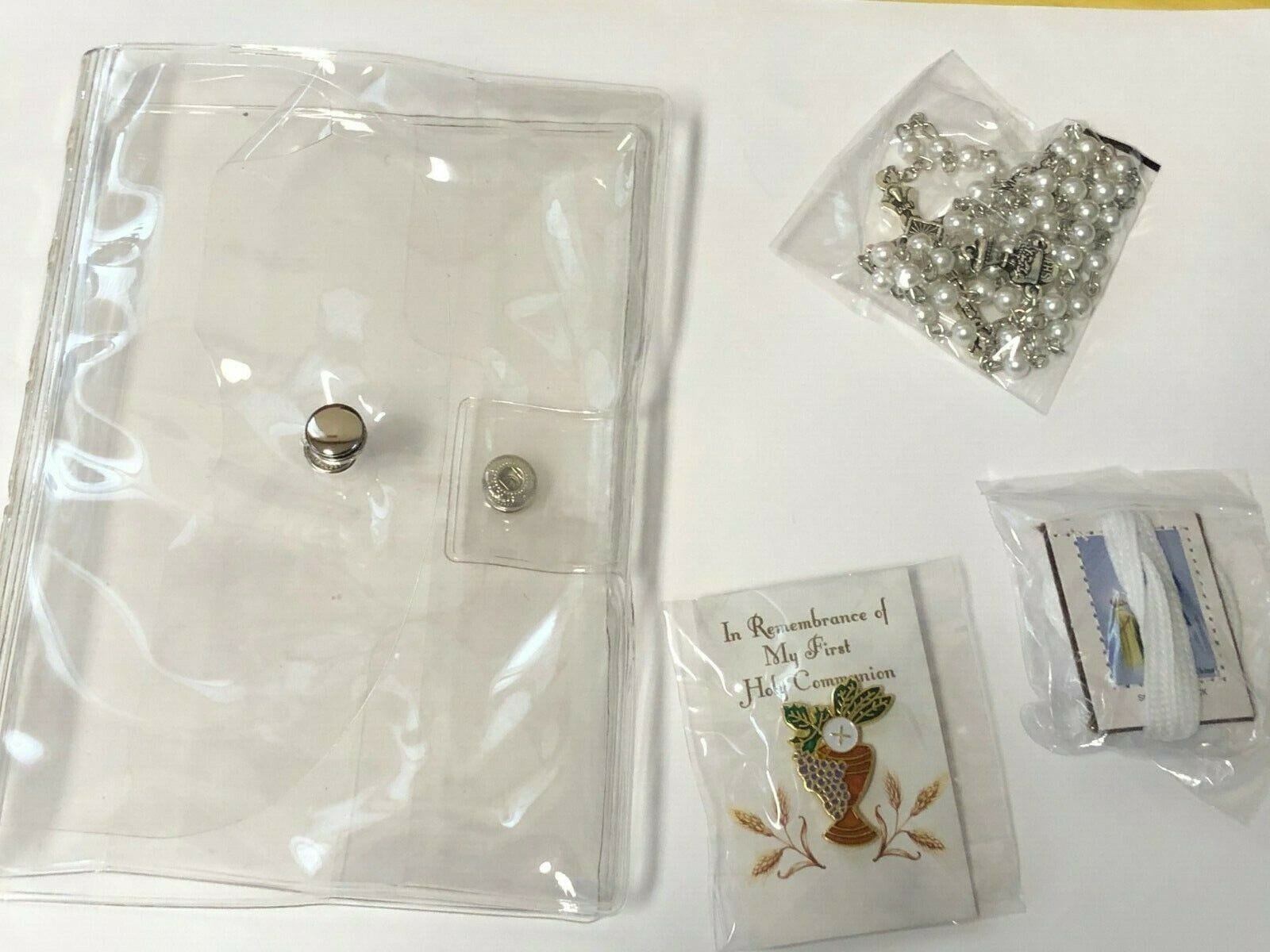 Girl's First Holy Communion wallet gift set, includes five Christian-themed collectibles, with religious symbols and decorative designs.