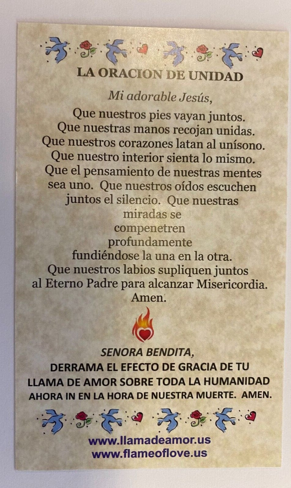 Holy card titled "La Flama de Amor del Inmaculado Corazon de Maria" by Bob and Penny Lord, featuring religious imagery and prayer text.